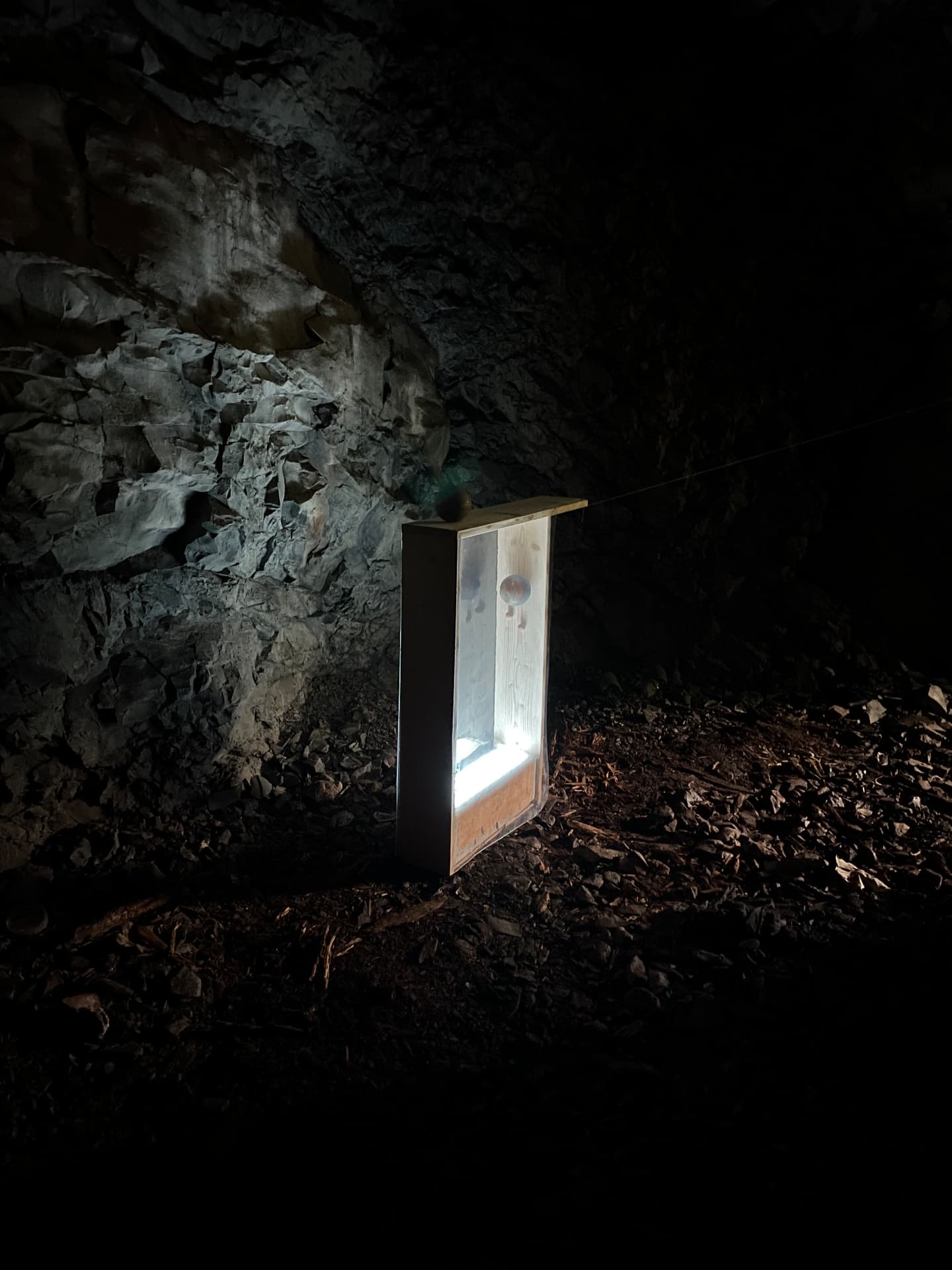 Illuminated wooden vitrine standing on the cave floor