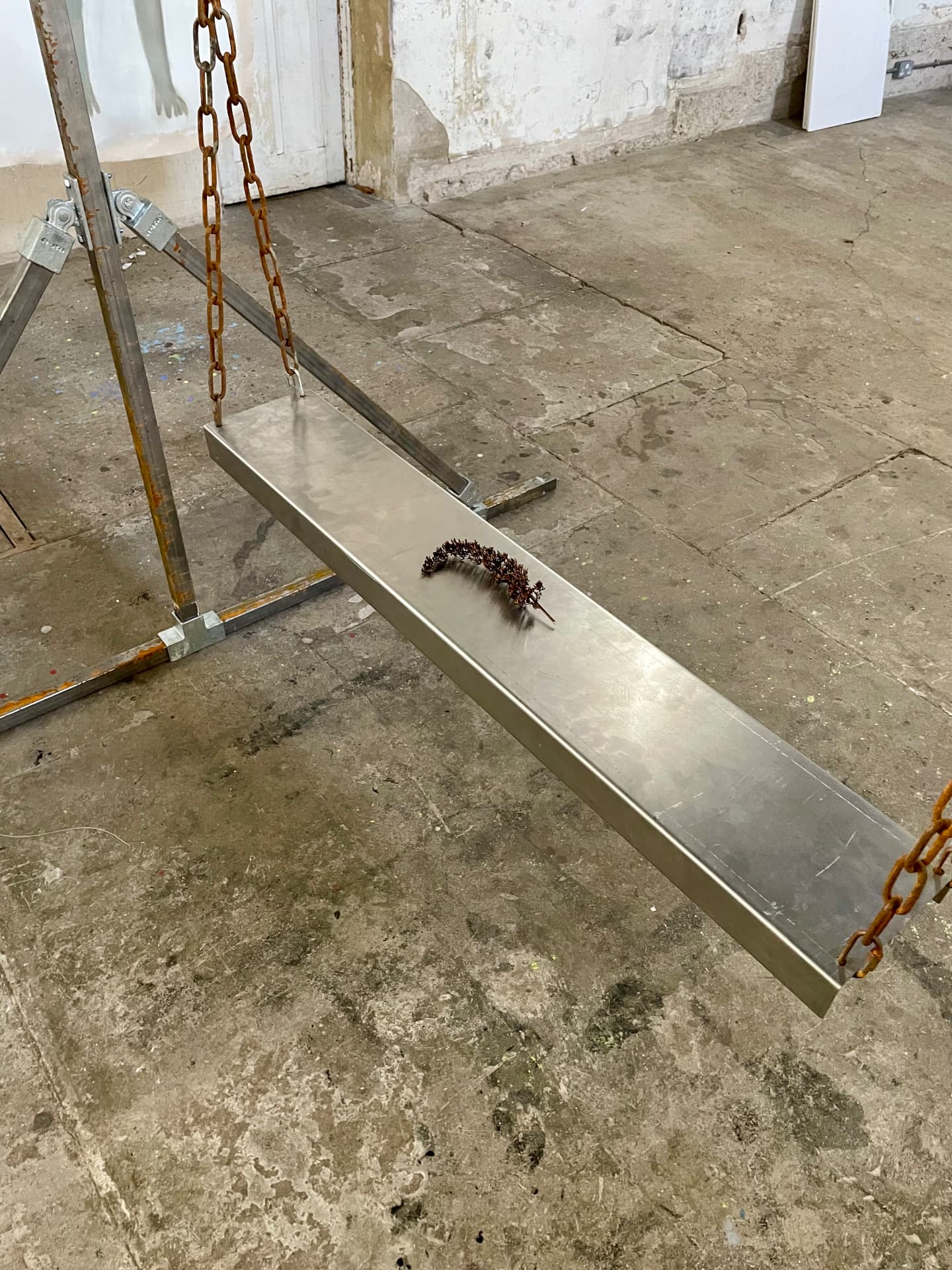 Polished steel shelf with dried lavender hanging by rusted chain
