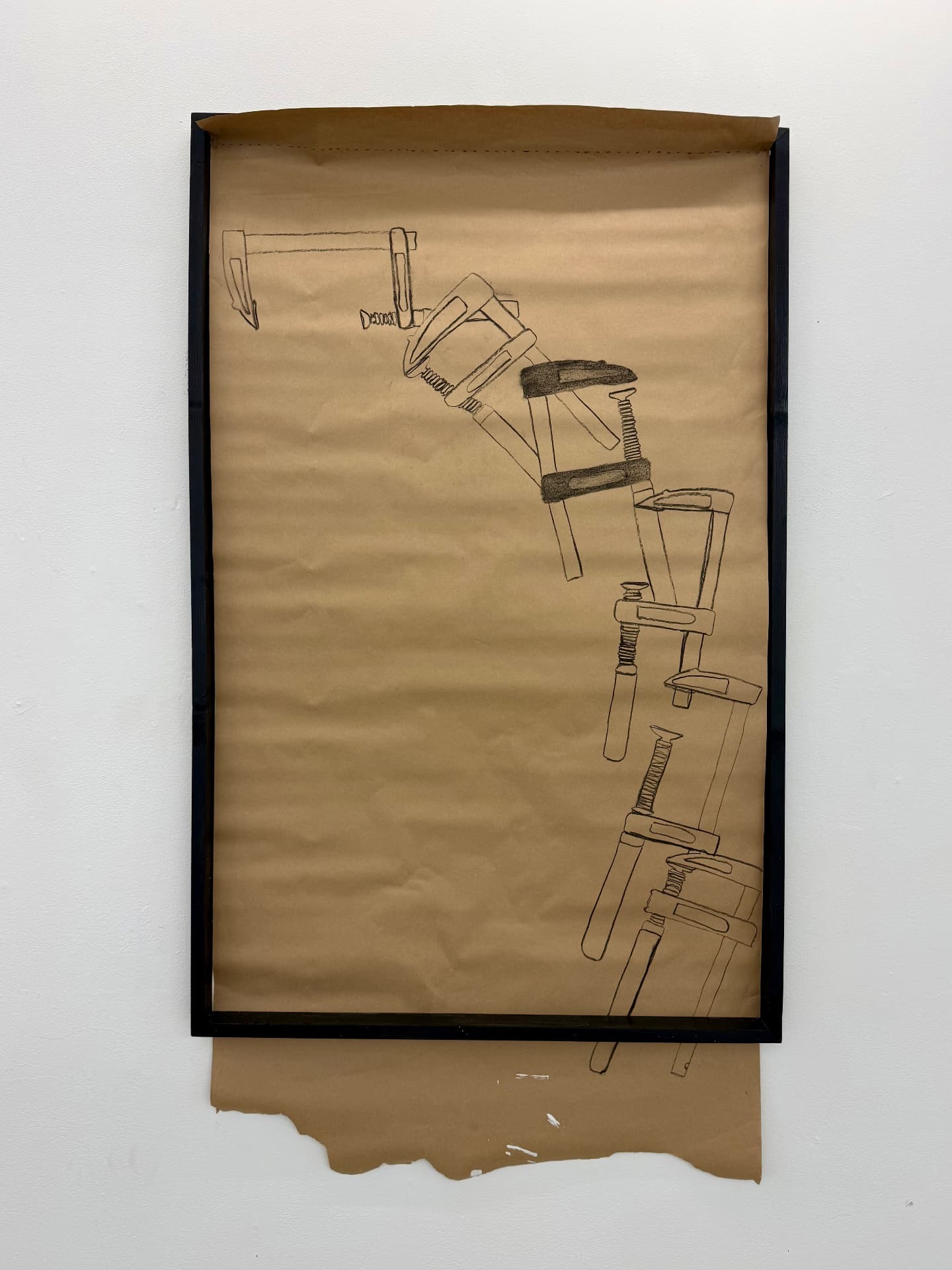 Charcoal drawing of clamps on brown paper in a black frame